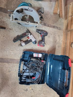 une boîte à outils contenant des outils, posée par terre à côté de lui