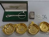 three gold plated bowls and spoons are sitting on a table