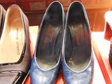 three pairs of blue shoes are on display in a store window