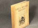an old book sitting on top of a table on a gray surface