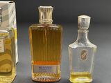three bottles of perfume sitting next to each other on top of a table