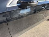 a car that has a broken door handle on the side of the road