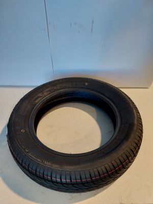 an old tire sitting on the floor next to a white wall