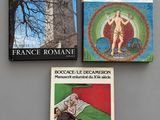 three books on a table with a clock tower in the background