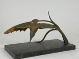 sculpture en bronze représentant un oiseau perché sur une branche, posée sur un socle en marbre