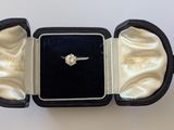 une bague dans un écrin noir sur fond blanc