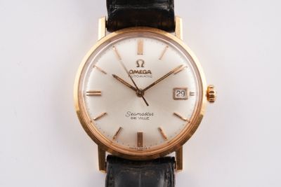 une montre-bracelet en or avec un cadran blanc et un bracelet noir