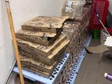 a pile of boxes on the floor next to a broom
