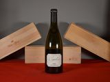 a bottle of wine sitting on a table next to two wooden boxes