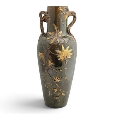 a green vase with gold flowers on it on a white background