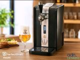 un gros plan sur un distributeur de bière et un verre de bière posé sur une table