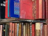 de nombreux livres qui se trouvent sur une étagère dans la pièce