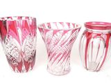 three glass vases sitting next to each other on a white surface