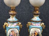 une paire de vases bleus et dorés sur lesquels est représenté un homme et une femme