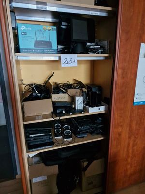 un placard rempli d'appareils électroniques et d'autres objets dans la pièce