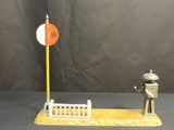 a small statue of a man standing next to a stop sign