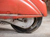 a red scooter that is parked in a garage