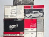 Plusieurs manuels de voitures anciennes sont posés sur une surface blanche