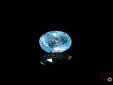 a close up of a blue diamond on a black surface