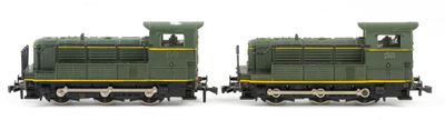 two toy trains sitting side by side on a white surface