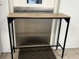 une petite table sur laquelle est posée une pancarte, dans une pièce