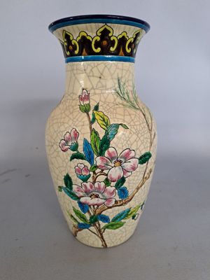 un vase orné d'un motif floral, posé sur une table