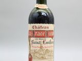 une bouteille de vin rouge posée sur une table blanche
