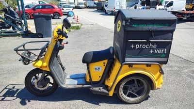 a yellow scooter with a box on the back of it