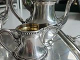 a silver tea pot sitting on top of a silver tray