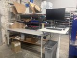 un bureau sur lequel se trouve un ordinateur, dans un entrepôt