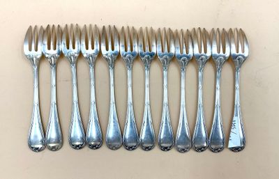 six fourchettes alignées sur une table