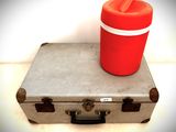 un gobelet rouge posé sur une valise