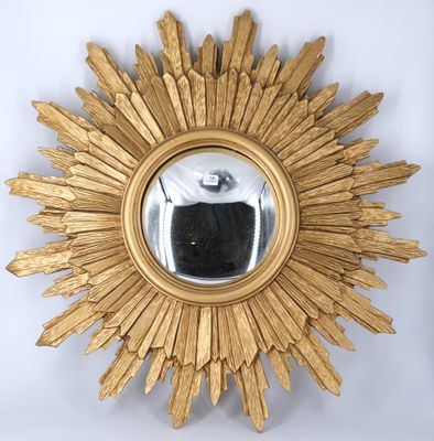 an image of a gold sunburst mirror on a white wall