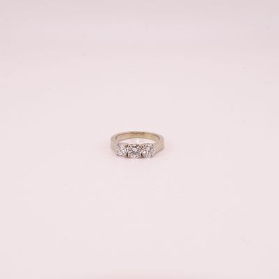 une bague de fiançailles ornée de trois diamants sur fond blanc