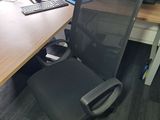 a desk with a computer and a chair in the room