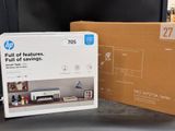 l'emballage d'une nouvelle imprimante HP posé sur une table à côté d'un carton contenant des produits HP