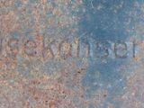 a close up of a rusted metal plate with writing on it