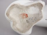 a white porcelain figurine with a red stamp on it