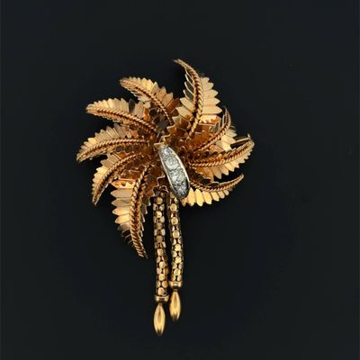 an image of a gold brooch with a palm tree on it