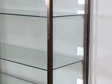 a glass display case on a wooden shelf in a room