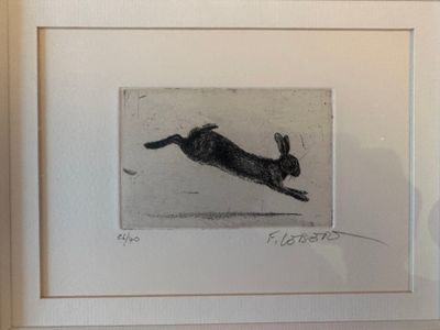 tableau représentant un chien noir bondissant dans les airs, dans un cadre blanc