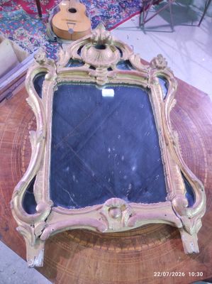 a mirror on a table with a guitar in the background