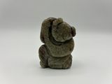 un gros plan d'une figurine d'ours en peluche posée sur une surface blanche