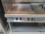 a silver stove with a grill top on it in a kitchen