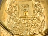 gold plated bell with a crown on top of it on a black surface