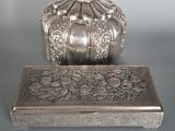 une boîte en argent posée sur une table à côté d'une autre boîte en argent