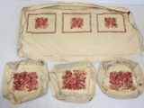 three pieces of cloth with red flowers on them on a white surface