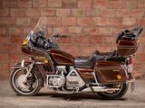 a brown motorcycle parked in front of a brick wall