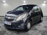 La petite voiture noire est garée dans le garage, sur le sol à carreaux.