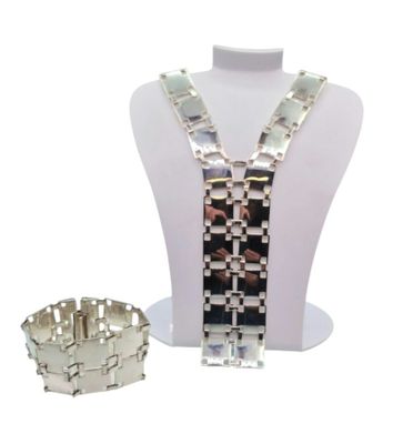 un collier et un bracelet posés sur un présentoir pour mannequin